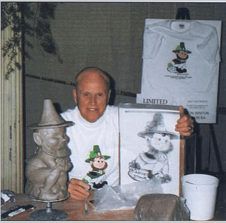 Man with leprechaun sculpture and t-shirts.