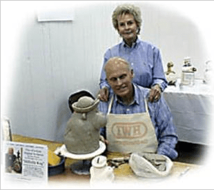 Couple posing with pottery at an art fair.