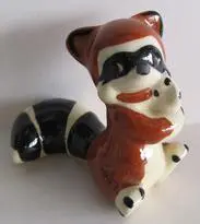 Ceramic figurine of a raccoon sitting.