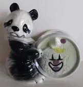 Ceramic panda holding a clown-faced plate.