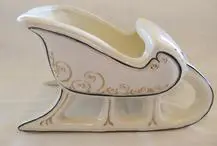 White porcelain Christmas sleigh with gold trim.