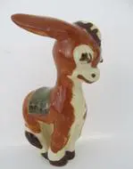 A ceramic donkey figurine with a saddle.