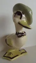 Ceramic duck figurine wearing a beret and bow tie.