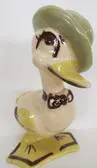 Ceramic duck figurine wearing a hat and bowtie.