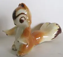 A brown and white ceramic squirrel figurine.