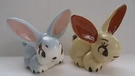 Two ceramic bunny figurines, one blue and one yellow.