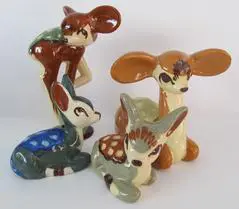 Four ceramic figurines of deer in various poses.