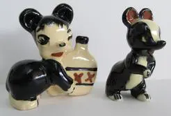 Two ceramic figurines of a bear and skunk.