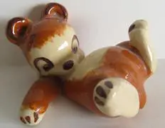 A ceramic figurine of a brown bear cub.