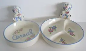 Two ceramic puppy-shaped bowls for children.