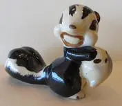 Ceramic skunk figurine with a baby skunk.