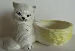 White ceramic cat planter with yellow bowl.