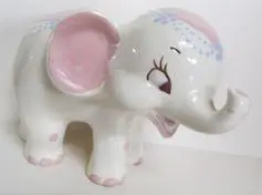 A white ceramic elephant with pink accents.