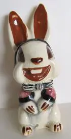 Smiling ceramic bunny with brown ears.