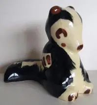 Ceramic figurine of a black and white skunk.