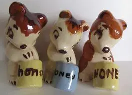 Three ceramic bears holding honey pots.