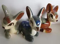 Three ceramic fawn figurines in various colors.