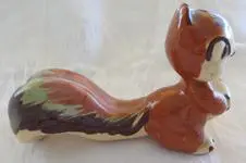 Ceramic squirrel figurine in brown and green.