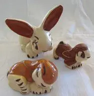 Ceramic rabbit and two brown puppies.