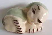 Ceramic figurine of a sleeping dog.