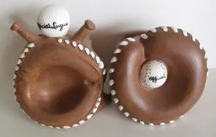 Two ceramic baseball glove and ball figurines.