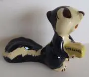 Ceramic figurine of a skunk holding a bar of soap.