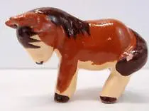 Brown and white ceramic figurine of a donkey.