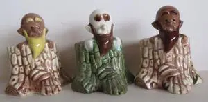 Three ceramic figurines of bearded men.