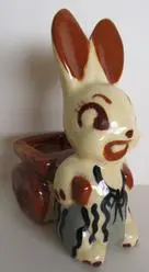 Ceramic bunny planter with wagon wheels.