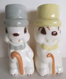 Two ceramic figurines of gentlemen in hats.