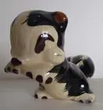 Ceramic figurine of a black and white dog.