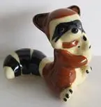 Ceramic figurine of a raccoon sitting.