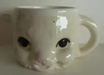 White ceramic mug shaped like a cat.