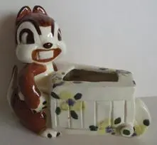 Chipmunk figurine pushing a floral wheelbarrow.