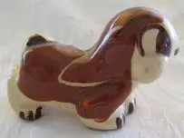 Ceramic figurine of a brown and white dog.