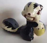 Ceramic figurine of a smiling skunk.