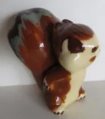 Ceramic squirrel figurine with brown and white glaze.