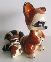 Ceramic raccoon figurine with baby raccoon.