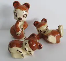 Three ceramic bear figurines in various poses.