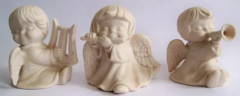 Three white porcelain angel figurines.