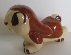 Ceramic figurine of a brown and white dog.