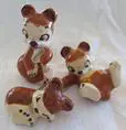 Three ceramic figurines of brown and white deer.