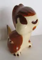 Ceramic figurine of a brown and white dog.