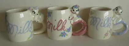 Four milk mugs with animal handles.