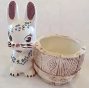 Ceramic rabbit figurine holding a planter.