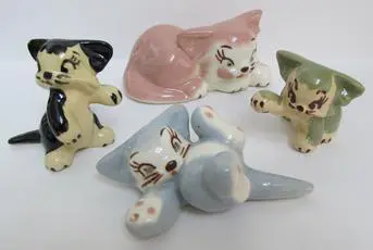 Four ceramic figurines of cartoon kittens.