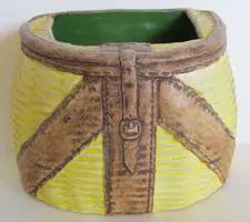 Yellow and brown ceramic planter with straps.