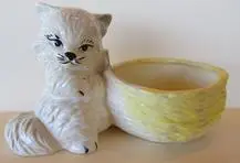 White ceramic cat planter with yellow bowl.