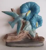 Ceramic figurine of a bird and flowers.