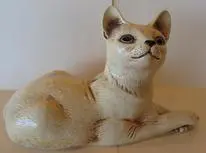 White ceramic cat figurine with brown eyes.